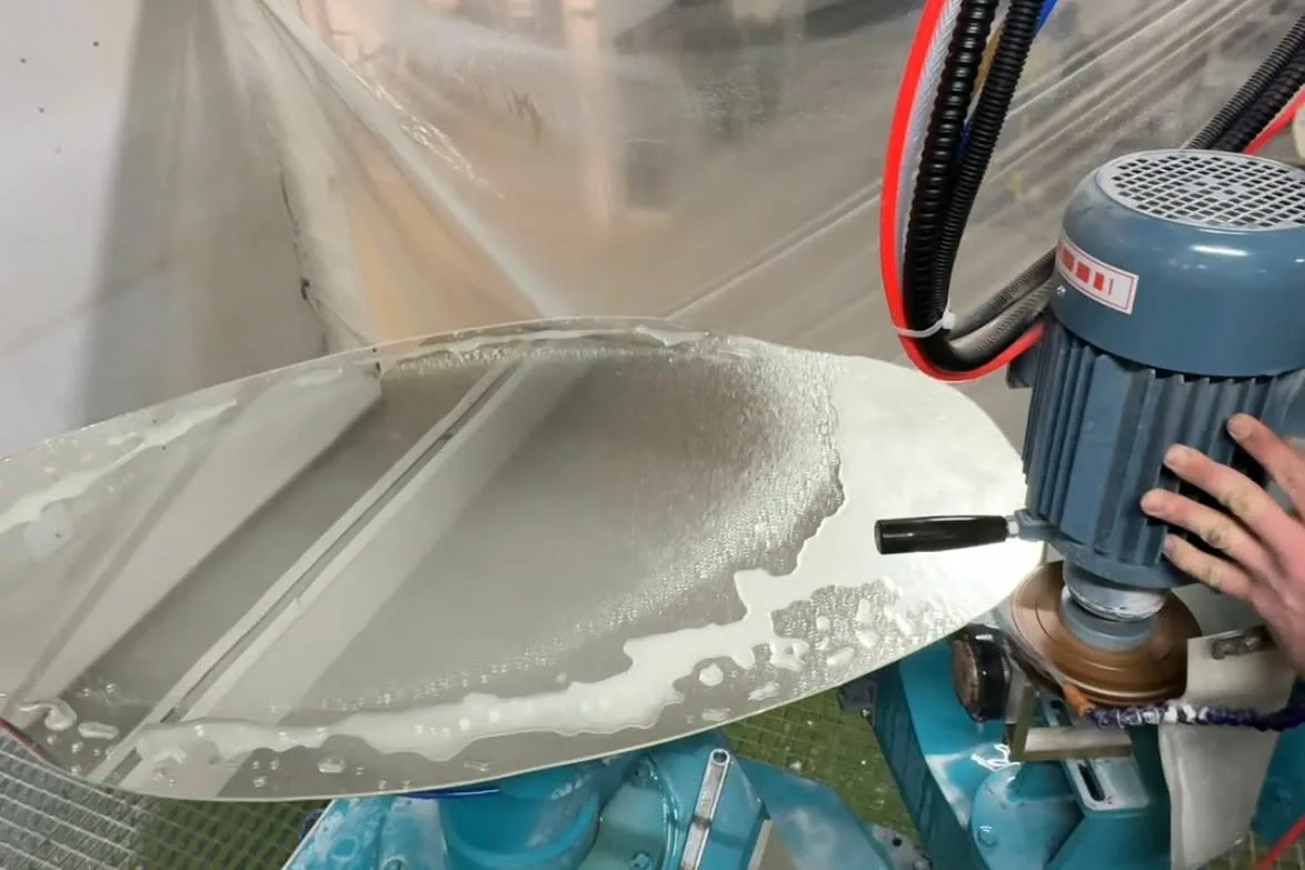 Kante eines runden Spiegels wird auf der Schleifmaschine mit Wasserkühlung poliert